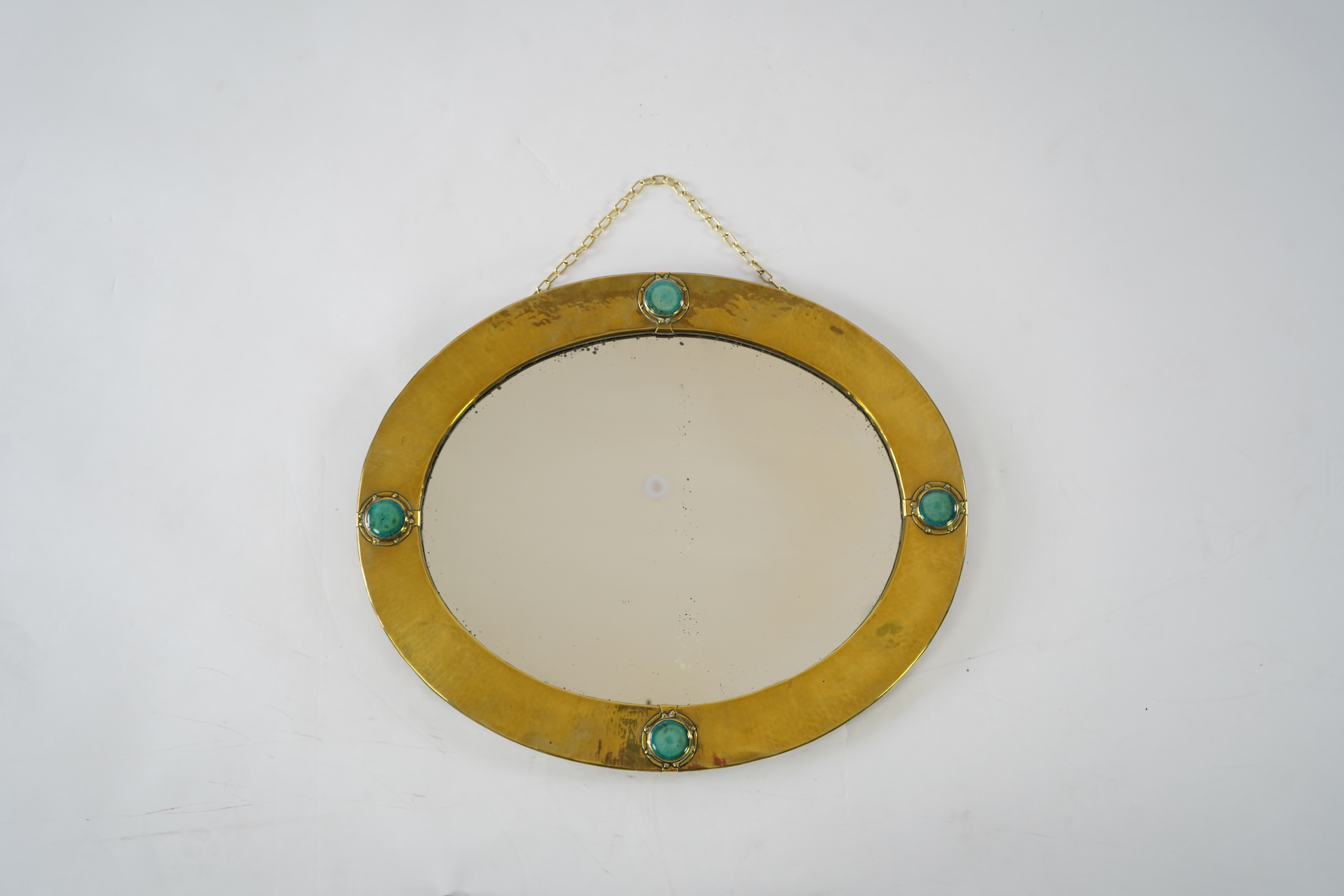 Liberty & Co.: An Arts And Crafts brass and Ruskin pottery cabochon mounted mirror